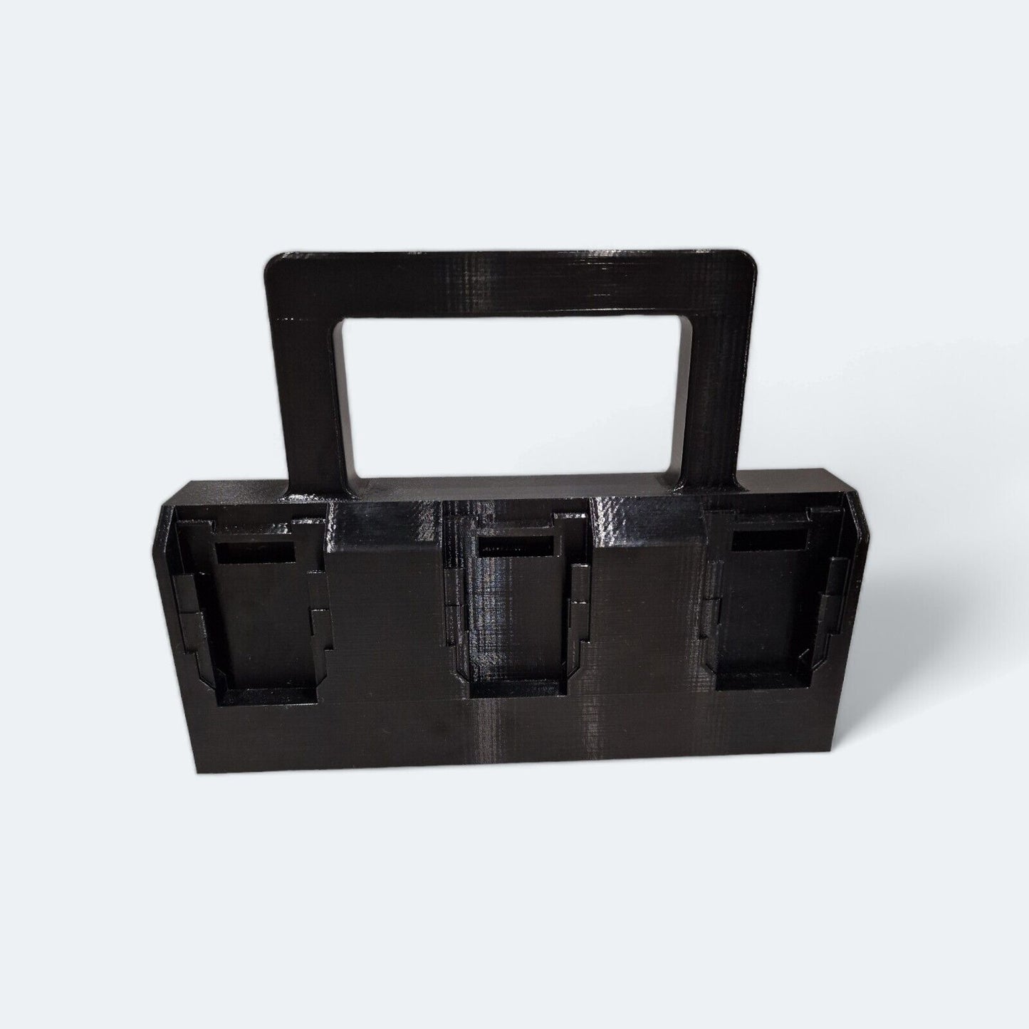 A black, rectangular 6x Battery Basket Carrier Caddy Holder for DeWALT by Ice3Dprints, featuring a handle and three compartments on a light gray background. These compartments are crafted to securely hold power tool accessories and efficiently organize your tools.